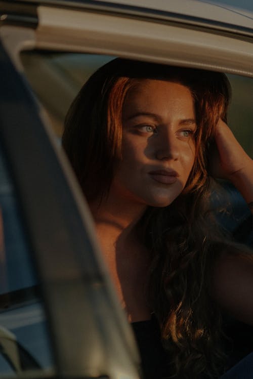 Woman in Black Tank Top Sitting Inside a Car