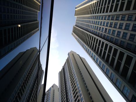 Low angle view of Jakarta skyscrapers reaching into a clear blue sky, showcasing urban architecture.