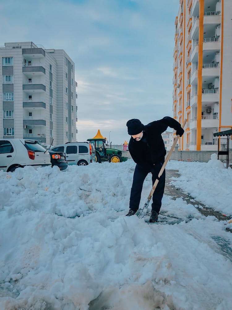 Man Shoveling Snow From A Sidewalk 