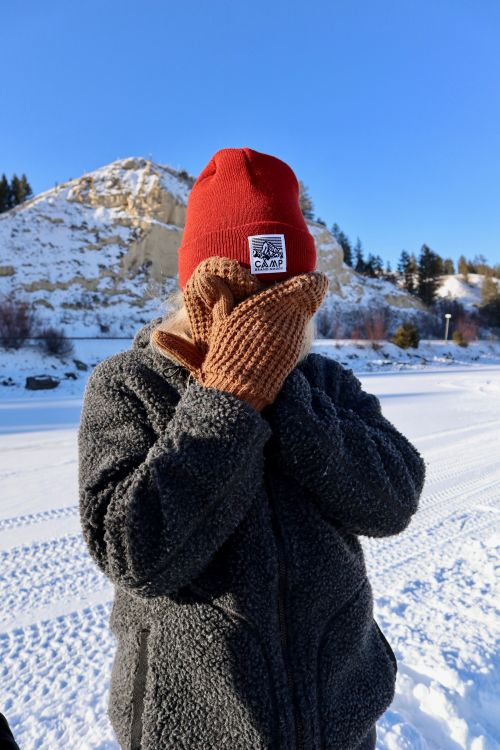Free Person covering their face with gloves and beanie on a bright winter day in Invermere, Canada. Stock Photo