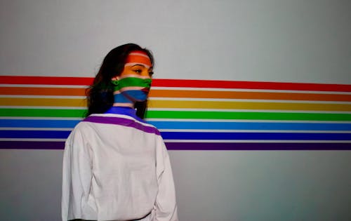 A Woman in a Sweater with a Rainbow Background