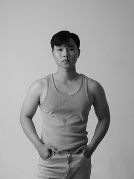 Classic black and white studio portrait of a man in casual wear posing with hands in pockets.