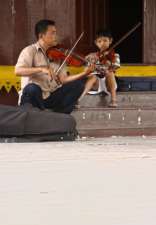 Free Man and Child Playing Violins Stock Photo