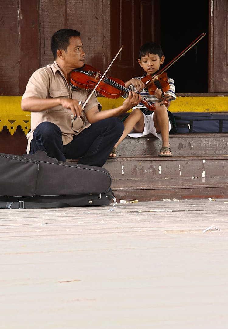 Man And Child Playing Violins