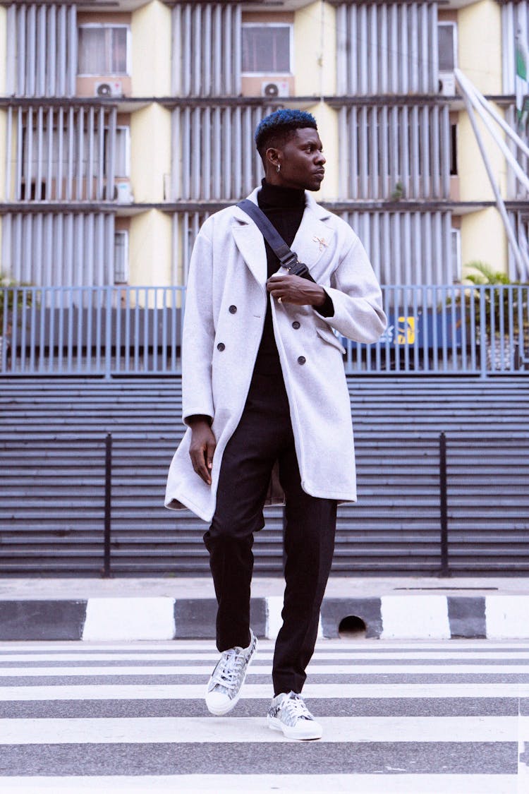 A Stylish Man In An Overcoat Crossing The Street