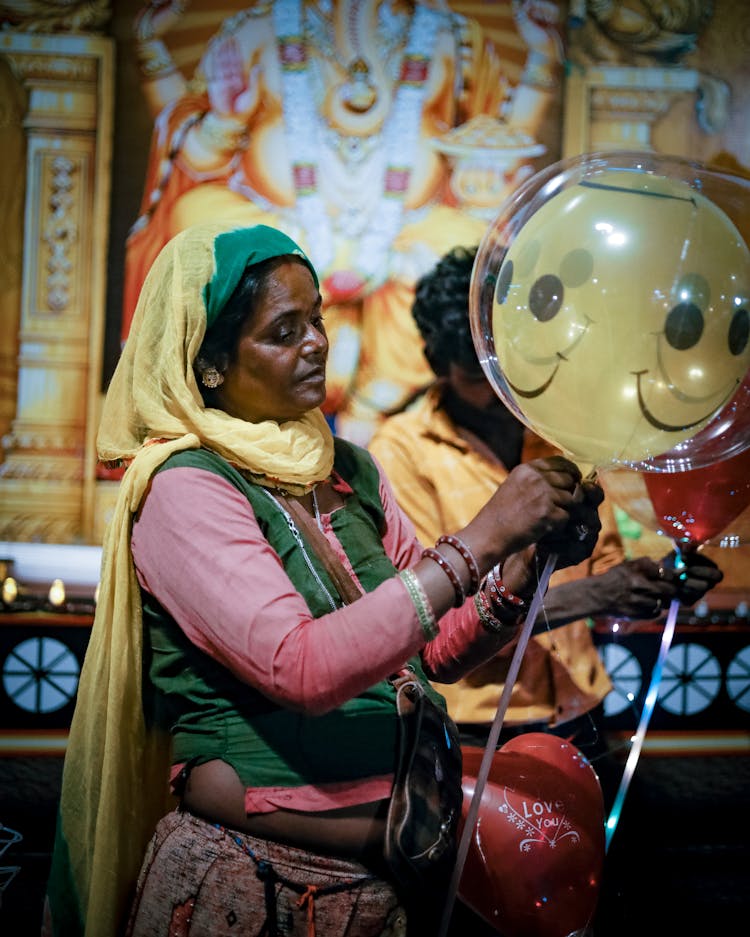 A Woman Making A Smiley Balloon