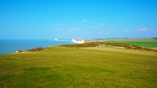 Free Breathtaking aerial view of Eastbourne's chalk cliffs and green pastures against a clear blue sky. Stock Photo