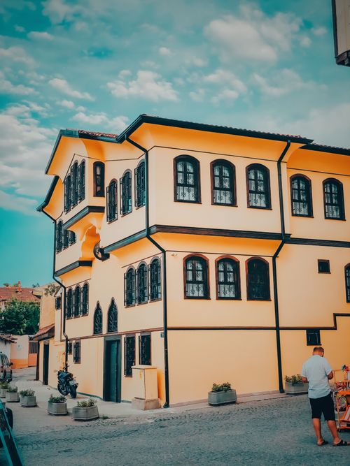 Free A picturesque yellow building with vintage windows and street view on a sunny day. Stock Photo