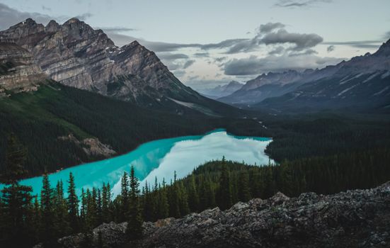 Experience the stunning turquoise waters of Peyto Lake surrounded by the majestic Rocky Mountains in Banff, Canada.