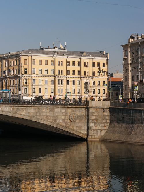 Free Serene urban landscape featuring a historic bridge, canal, and residential buildings. Stock Photo