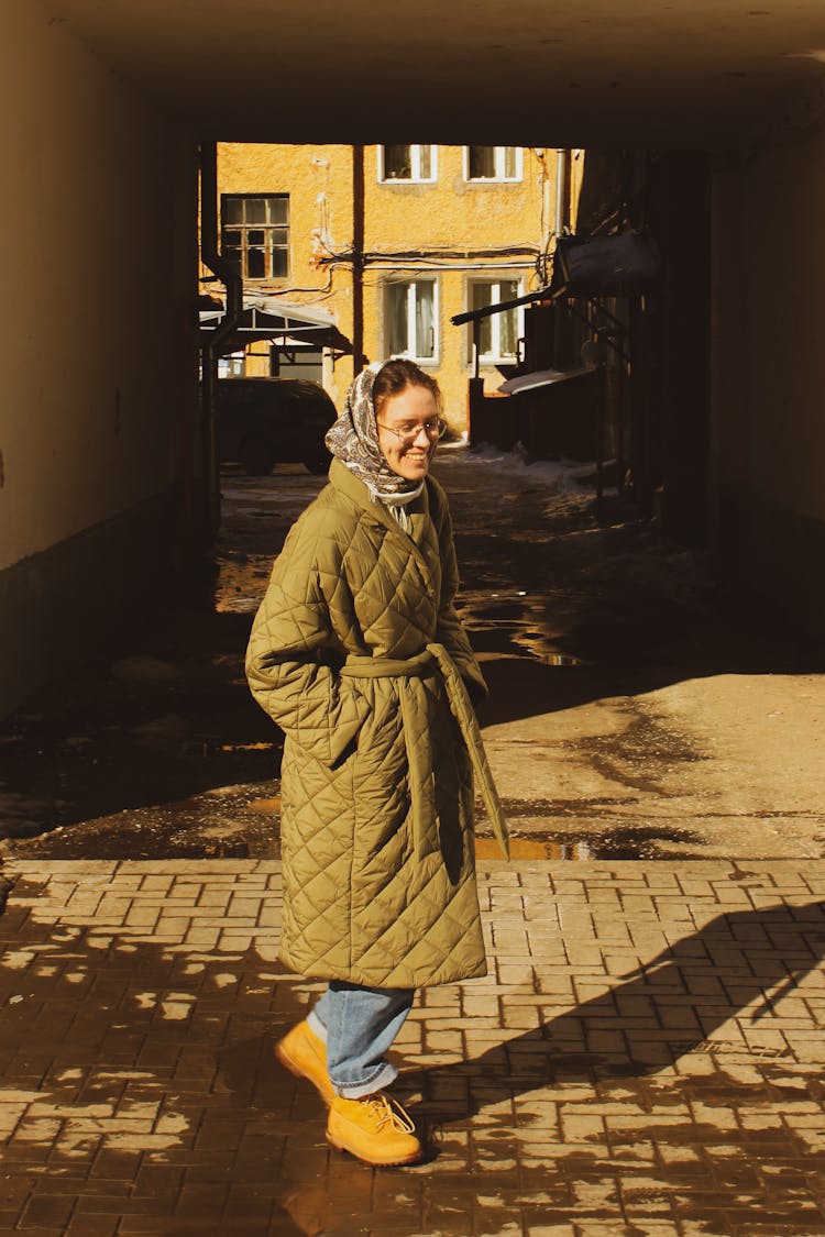 A Woman In A Headscarf And Quilted Coat