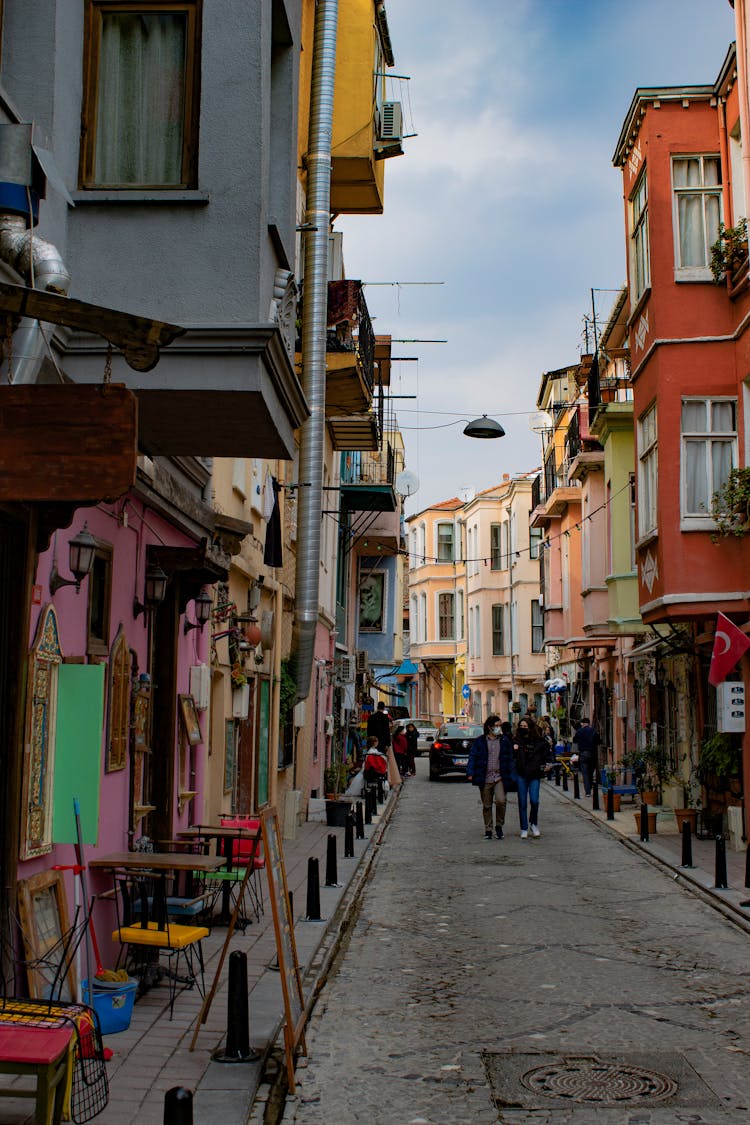 People Walking In The Street Between Colorful Houses