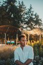 Young Man in White Shirt Sitting in Park at Sunset