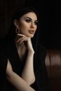 Beautiful Brunette Woman in Black Dress Sitting and Propping Head Up