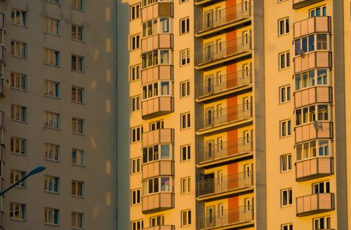 Free Warm sunlight casts shadows on urban residential buildings with balconies. Stock Photo