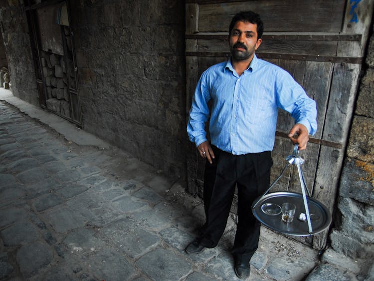 A Man Standing With A Tray