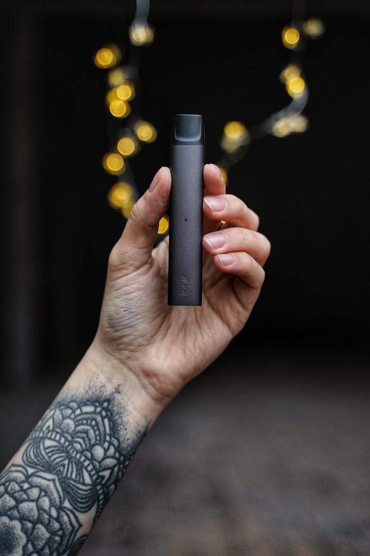 Man With Tattooed Arm Holding Logic Vape Pen