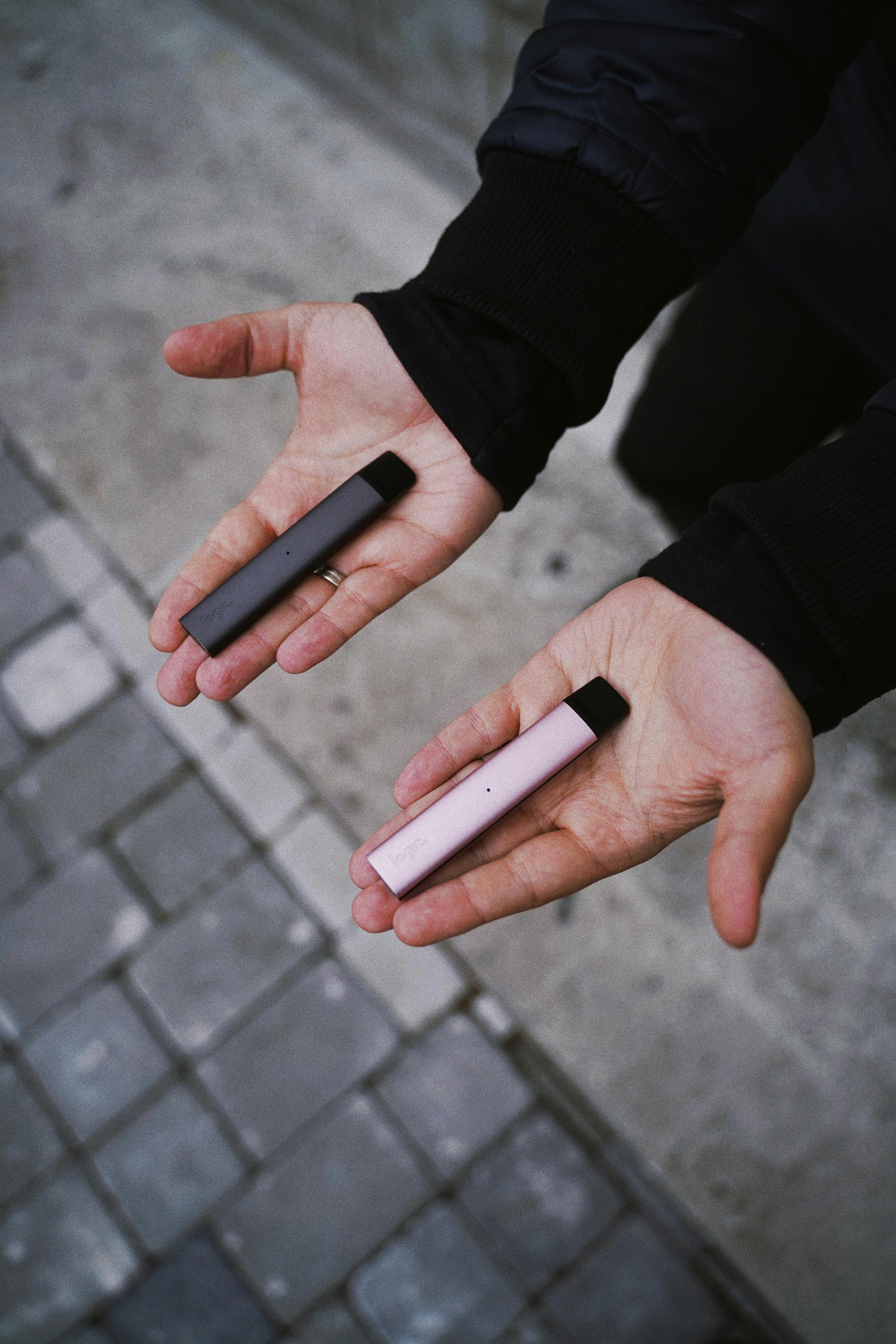 Free Man Holding Logic Vape Pens in Hands Stock Photo