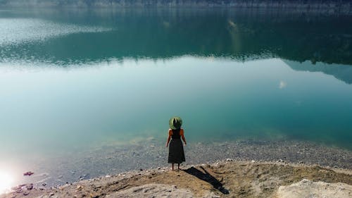 Drone Shot of a Woman Standing Near the Lake 