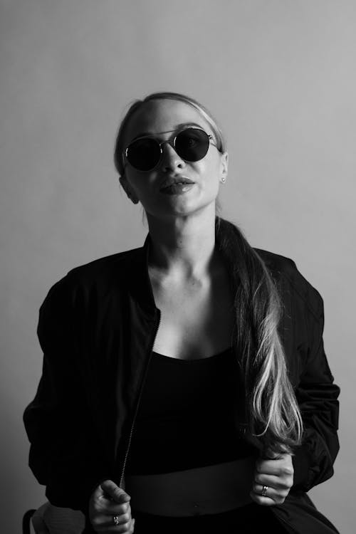 Blond Woman Posing for Photo in Sunglasses and Black Outfit