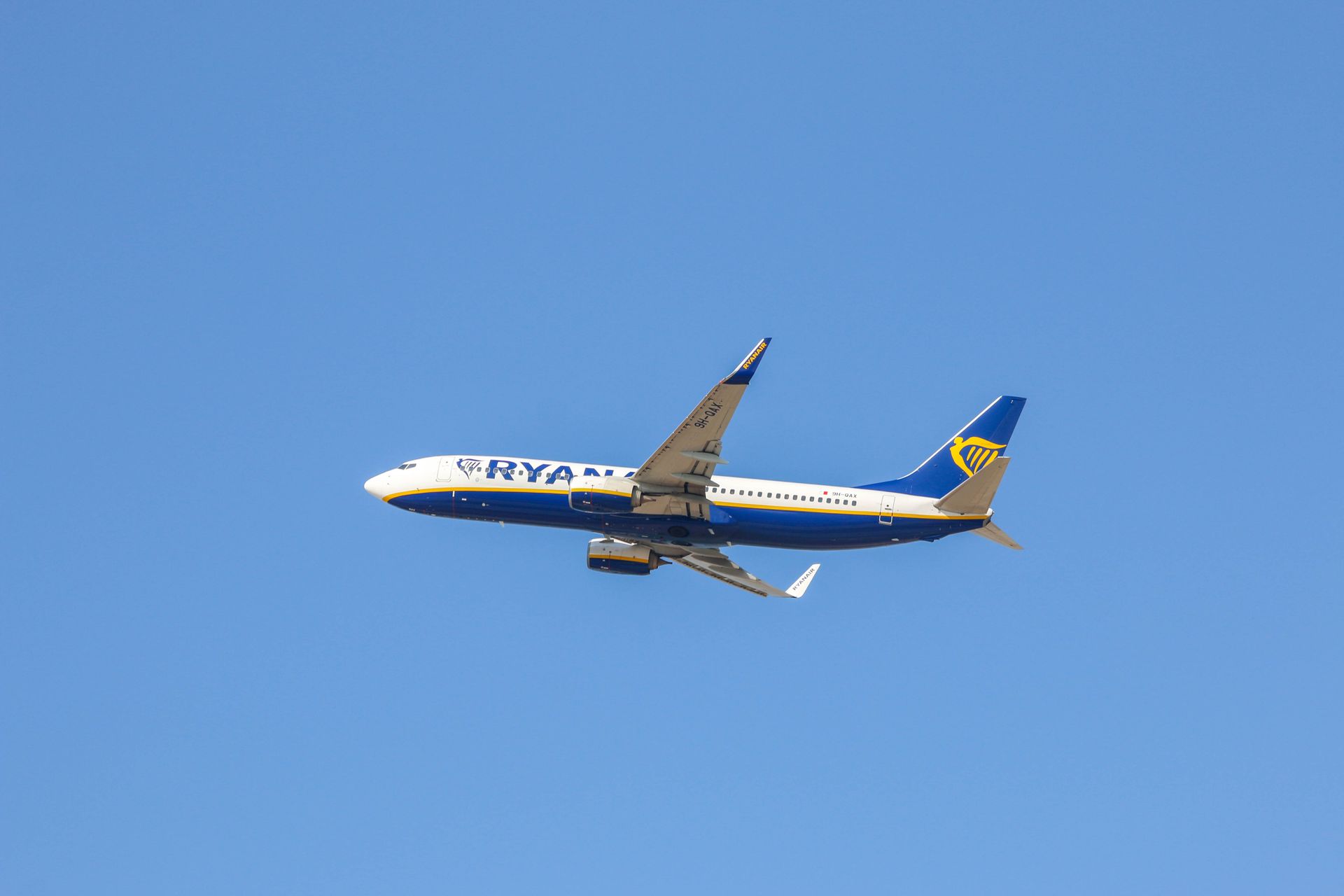 Ryanair aircraft captured against a vivid blue sky, showcasing flight and travel.