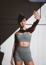 Blond Fitness Model in Gym Outfit Covering Sun with Outstretched Hand