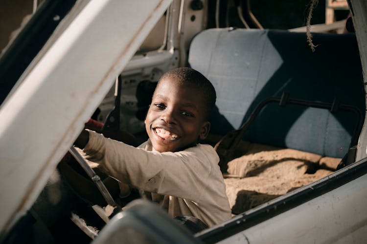 A Happy Boy Inside A Car