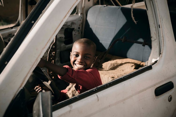 A Happy Boy Inside A Car