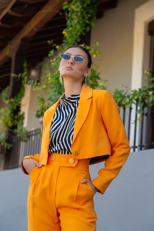 Free Woman in Sunglasses Posing in Orange Suit Stock Photo