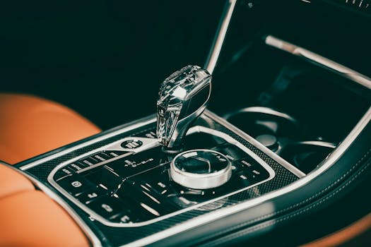 Close-up of a sleek gear lever in a luxury car interior featuring modern design elements.