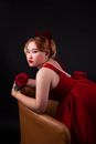 Woman in Red Dress Holding Rose Posing on Armchair