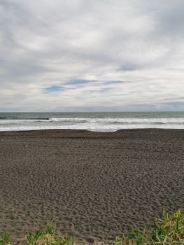 A captivating view of the volcanic sand beach in Petropavlovsk-Kamchatskiy under a cloudy sky.. captivating, view, volcanic