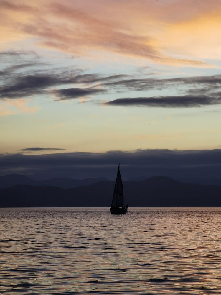 Sailboat In Sea Against Storm Clouds