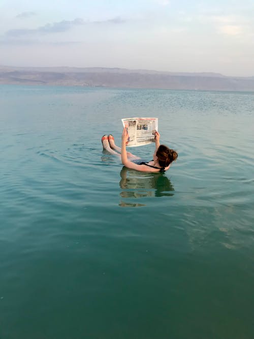 A Person Reading a Newspaper while Floating in the Dead Sea