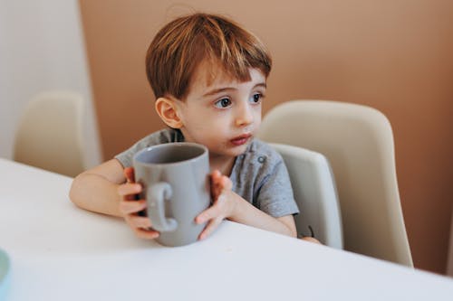 Cute Young Boy holding a Mug 