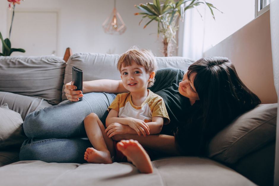 A loving mother and her young son enjoying quality time together on the living room couch.