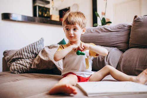 Boy Sitting on Living Room Couch Playing