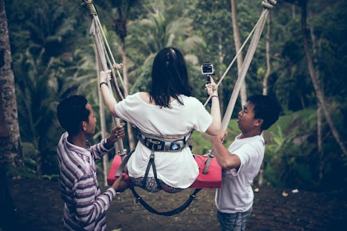 Free Two Men Assisting Woman Riding on Swing Stock Photo