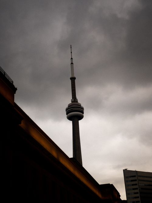 Free Dramatic view of Toronto's CN Tower against a cloudy sky, capturing the iconic skyline. Stock Photo