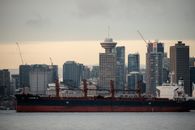 Red and White Ship on Sea Near City Buildings