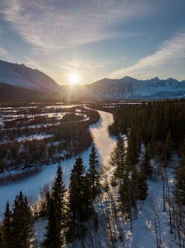 A breathtaking aerial shot of snowy landscape and mountains in Yukon, Canada during sunrise.