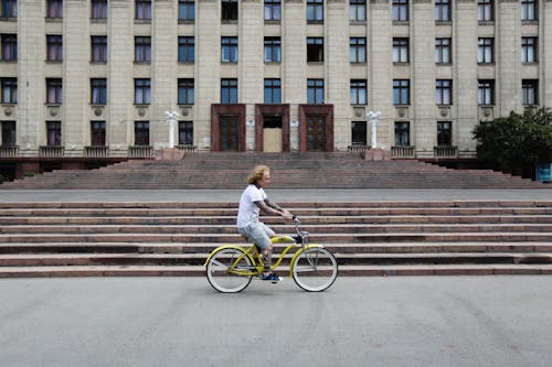 A Man Riding a Bike in Front of a Building