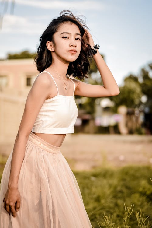 Beautiful Young Woman in White Tank Top and Pink Skirt 