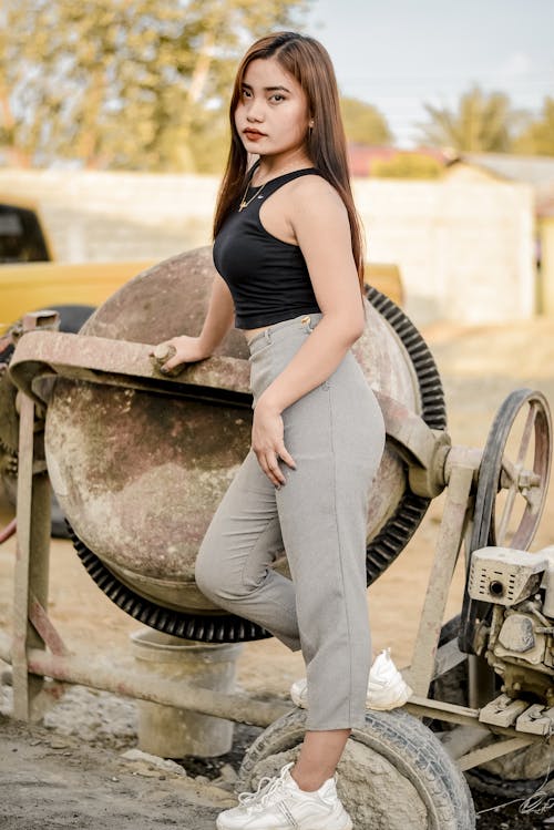 Beautiful Young Woman in Black Tank Top and Gray Pants 