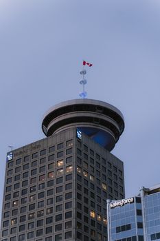 The Vancouver Lookout Tower with Canadian flag during evening in downtown Vancouver, BC, Canada.