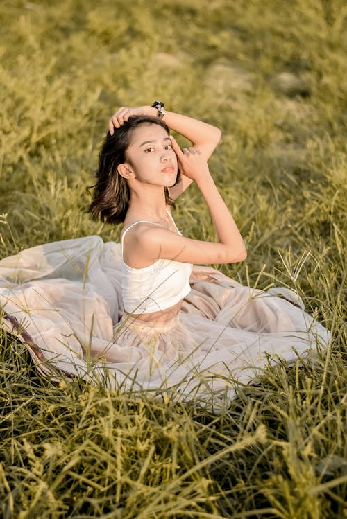 Beautiful Young Woman sitting on Grass