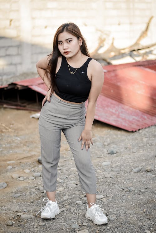 Beautiful Young Woman in Black Tank Top and Gray Pants