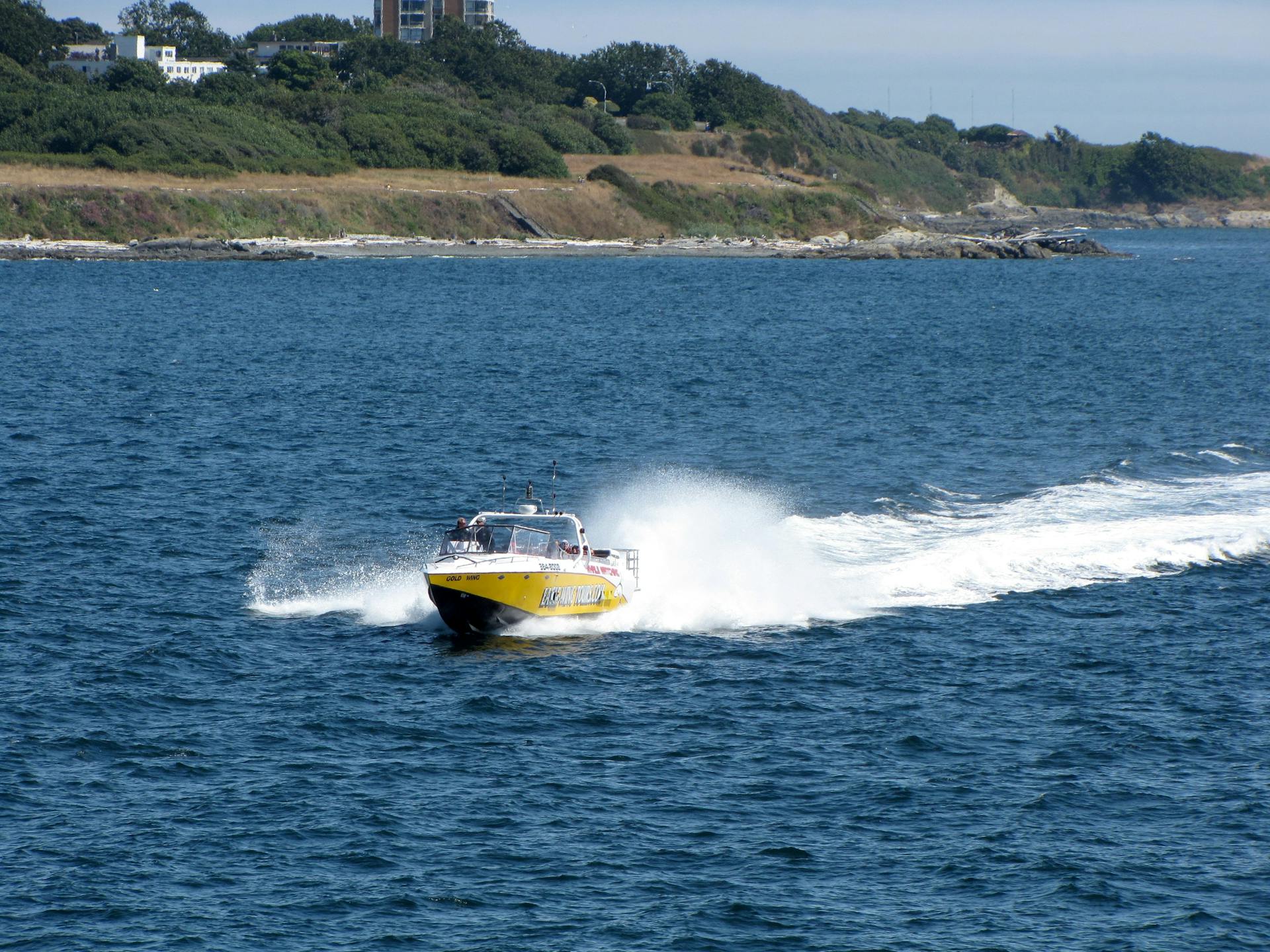 Yellow speedboat cruising in the ocean near West Vancouver coast.