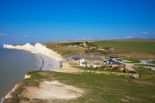 Free Explore the breathtaking aerial view of Eastbourne's iconic white cliffs under a clear blue sky. Stock Photo