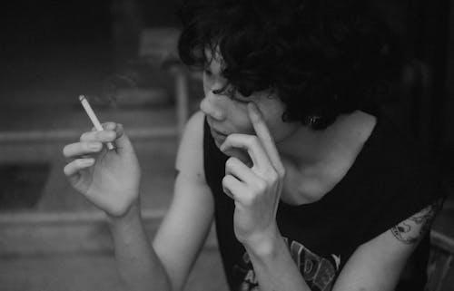 Grayscale Photo of a Man Smoking